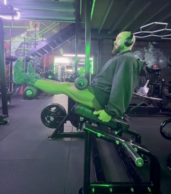 A member training on a machine with green-accented frames